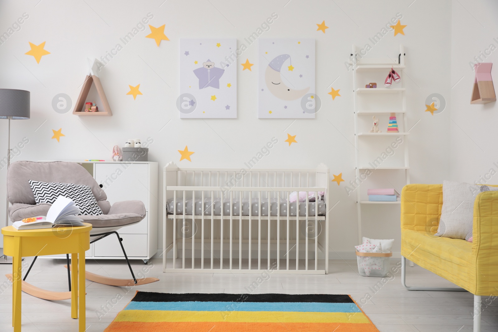 Photo of Stylish baby room interior with crib, rocking chair and sofa