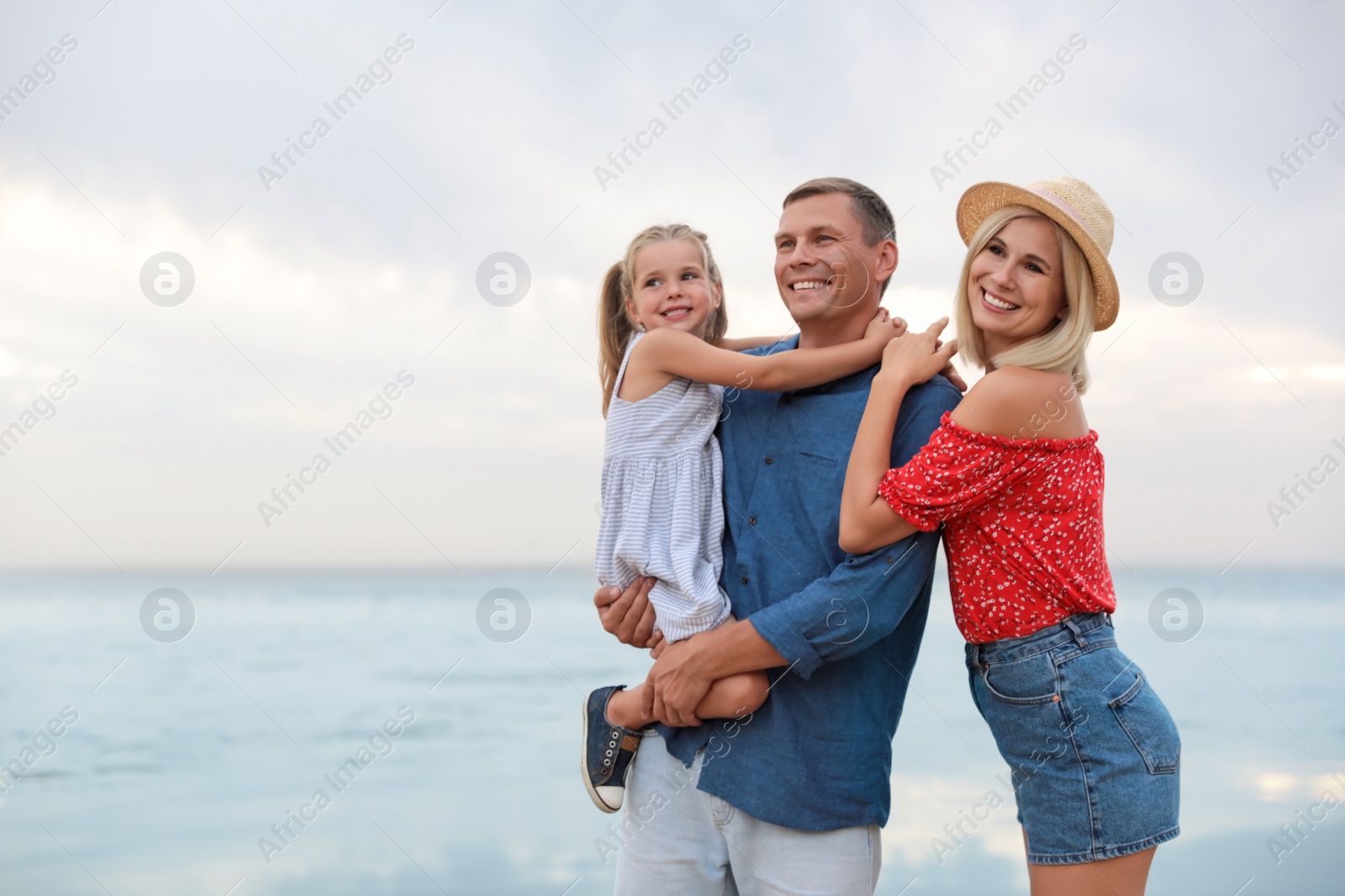 Photo of Happy family spending time together near sea on sunny summer day