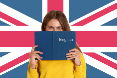Image of Beautiful young woman with book and flag of Great Britain as background. Learning English