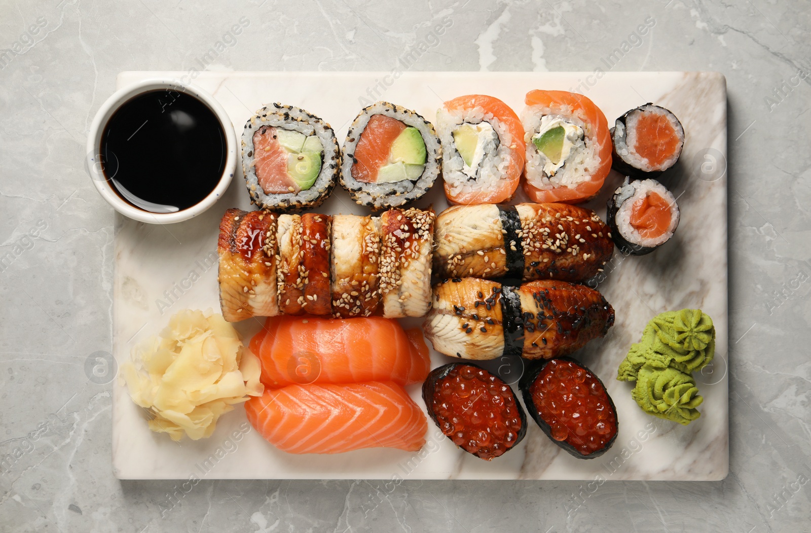 Photo of Set of tasty sushi rolls on light grey marble table, top view