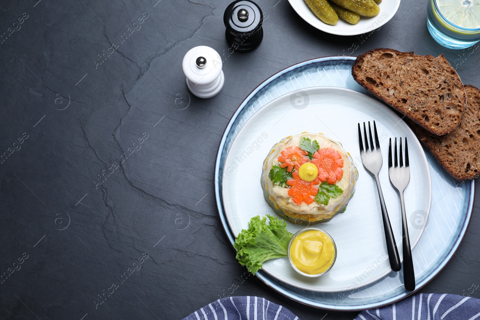 Photo of Delicious chicken aspic served on black table, flat lay. Space for text