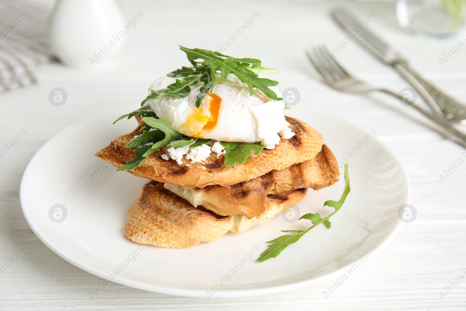 Photo of Delicious sandwich with arugula and egg on white wooden table, closeup