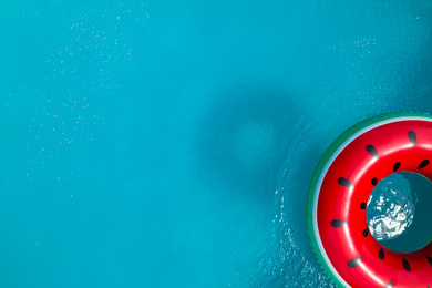 Top view of inflatable ring floating in swimming pool, space for text. Summer vacation