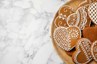 Tasty heart shaped gingerbread cookies on white marble table, top view. Space for text