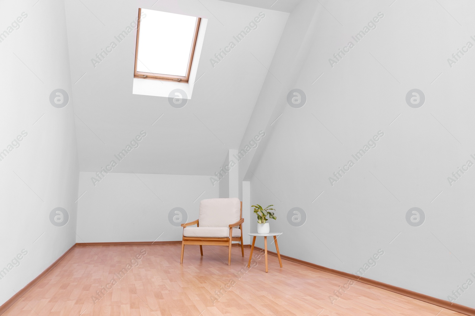 Photo of Attic spacious room interior with slanted ceiling and furniture