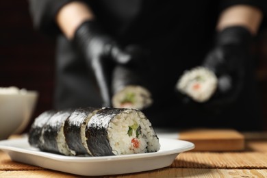 Tasty sushi rolls on wooden table, closeup