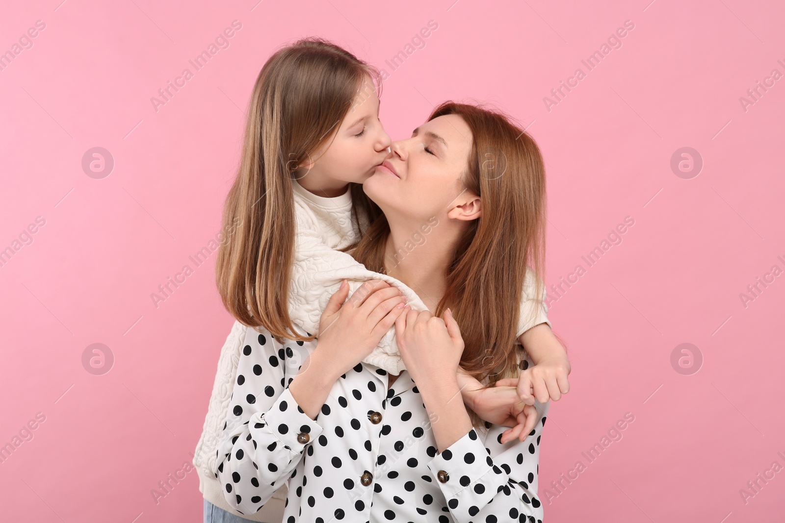 Photo of Portrait of happy mother and her cute daughter on pink background