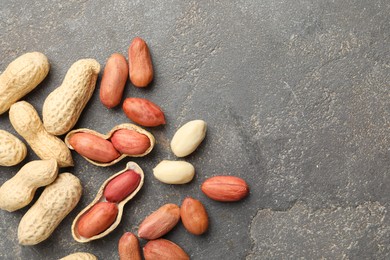 Fresh peanuts on grey table, flat lay. Space for text