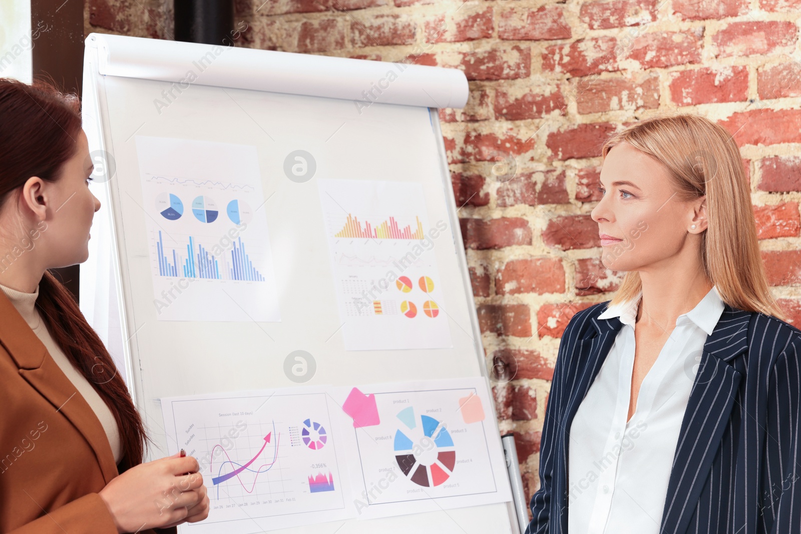 Photo of Businesswoman having meeting with her employee in office. Lady boss