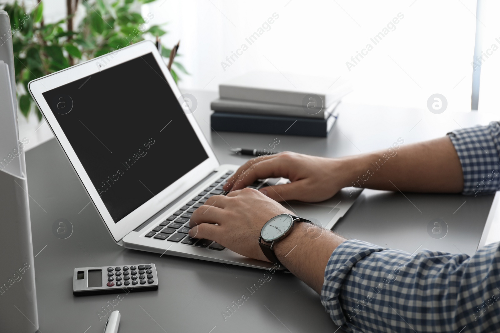 Photo of Man working with laptop at table, closeup. Space for design