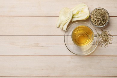 Photo of Aromatic fennel tea, seeds and fresh vegetable on wooden table, flat lay. Space for text