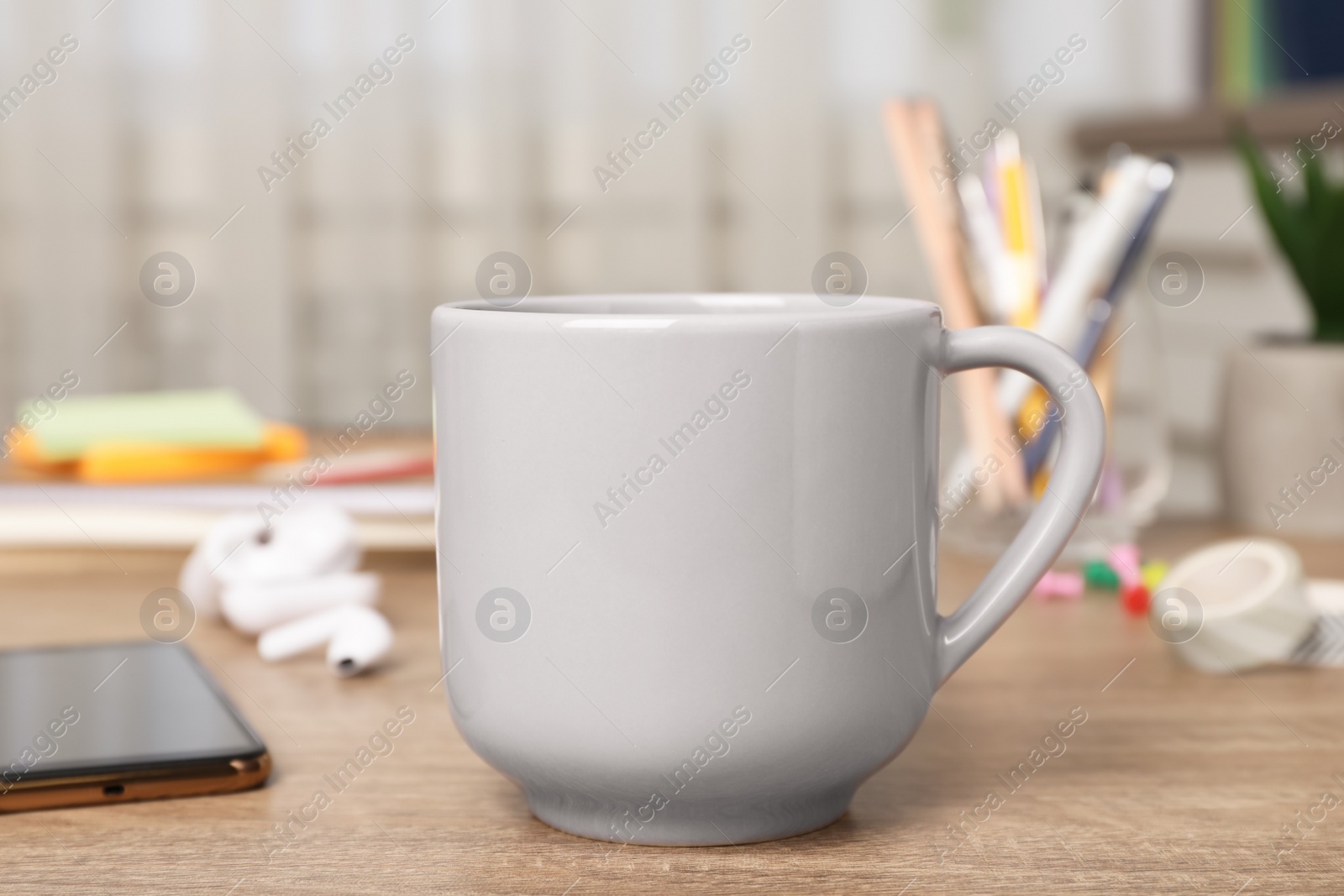 Photo of Coffee Break at workplace. Cup of hot drink on wooden table