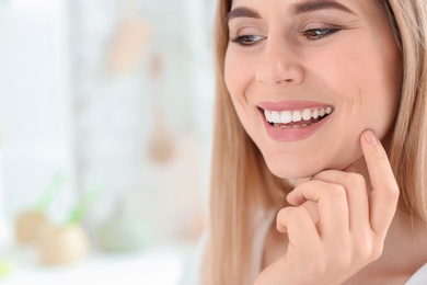 Young woman with beautiful smile indoors. Teeth whitening