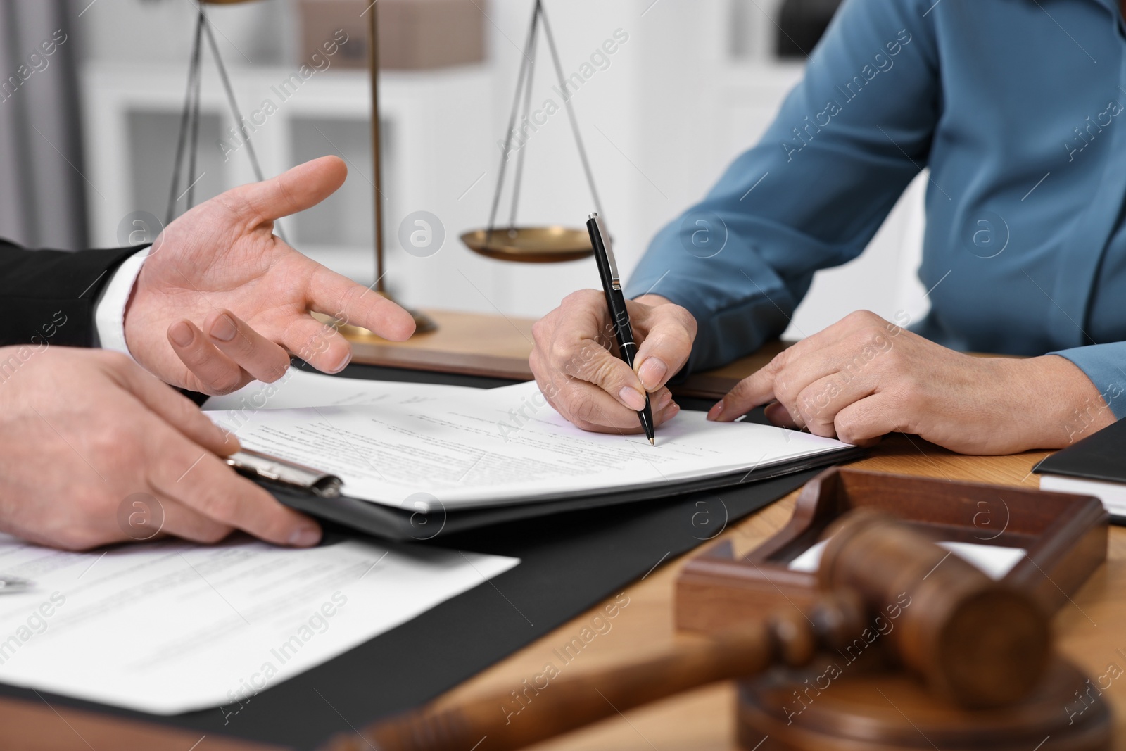 Photo of Senior woman signing document in lawyer's office, closeup