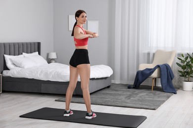 Woman doing morning exercise at home, space for text