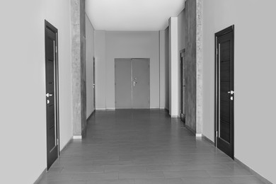 Photo of Empty office corridor with wooden doors. Interior design