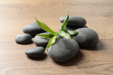 Spa stones and bamboo sprout on wooden table