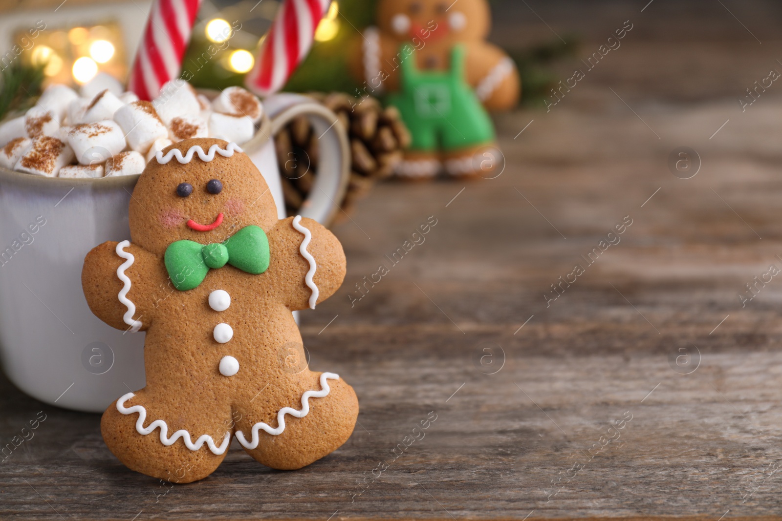 Photo of Gingerbread man and hot drink on wooden table, space for text