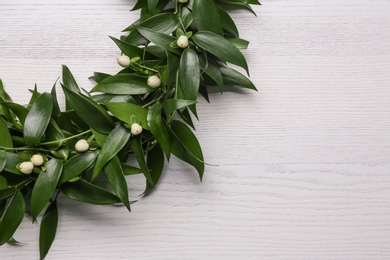 Photo of Beautiful handmade mistletoe wreath on white wooden table. Space for text
