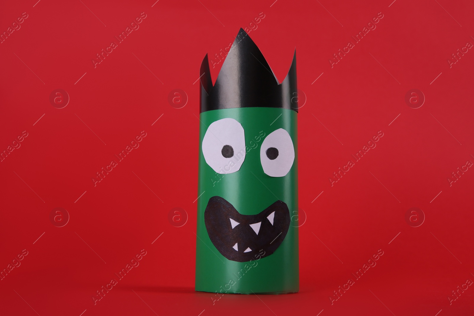 Photo of Funny green monster on red background. Halloween decoration