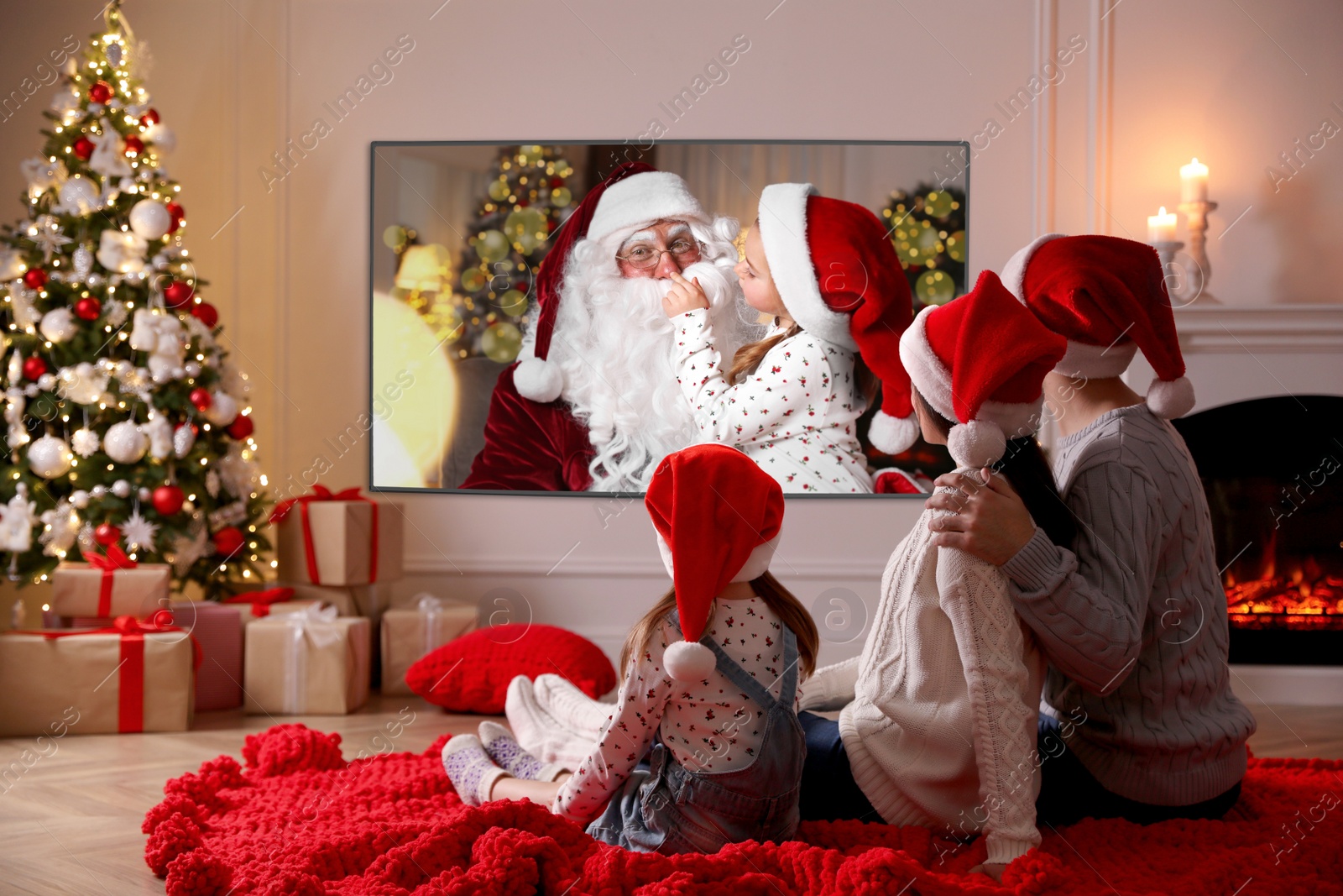 Image of Family watching TV movie in room decorated for Christmas