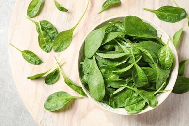 Photo of Bowl of fresh green healthy spinach on table, flat lay