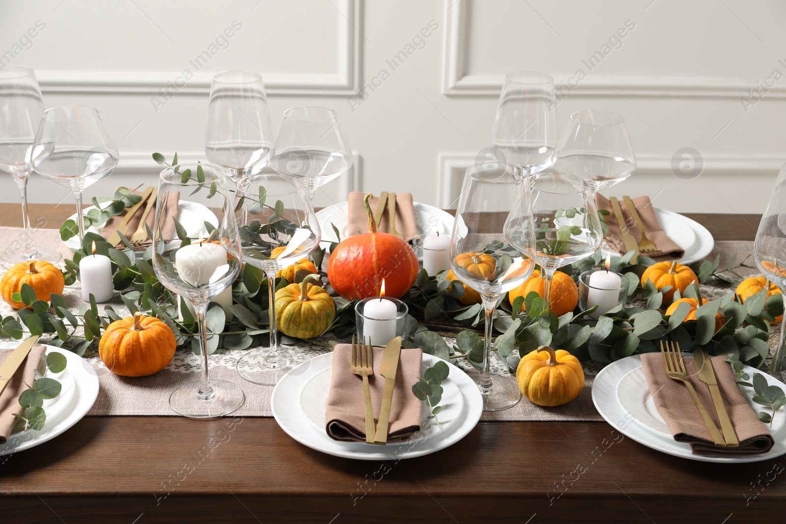 Photo of Beautiful autumn table setting. Plates, cutlery, glasses, pumpkins and floral decor