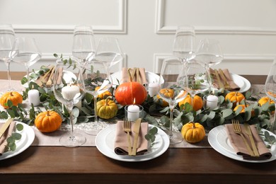 Photo of Beautiful autumn table setting. Plates, cutlery, glasses, pumpkins and floral decor