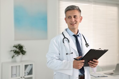 Photo of Doctor with stethoscope and clipboard in clinic, space for text