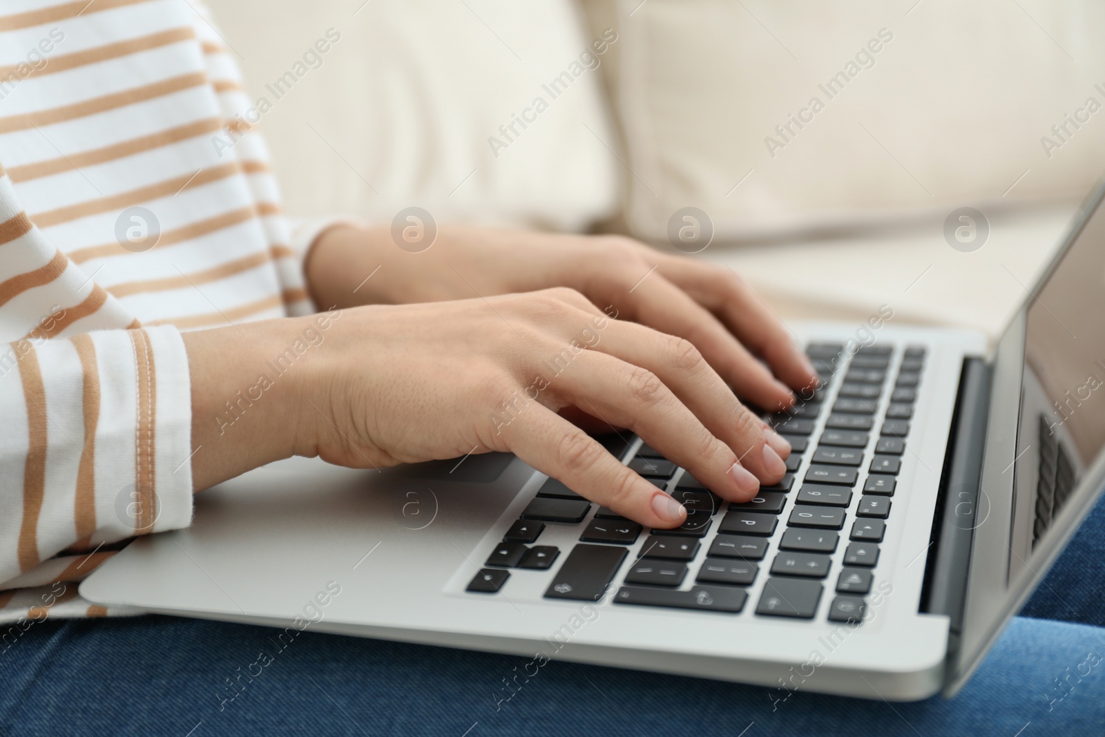 Photo of Woman working on modern laptop at home, closeup