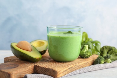 Photo of Glass with healthy detox smoothie and ingredients on table