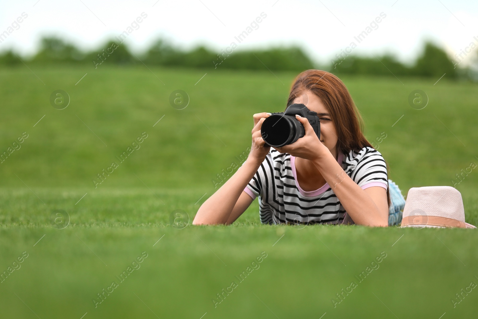 Photo of Photographer taking photo with professional camera in park. Space for text