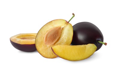 Whole and cut ripe plums on white background