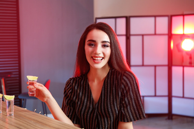 Photo of Young woman with Mexican Tequila shot at bar