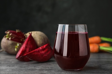 Glass with fresh healthy beet juice on table