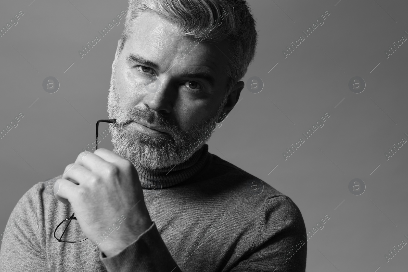 Photo of Portrait of handsome man on grey background. Black and white effect