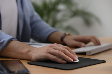 Man working on computer at table in office, closeup