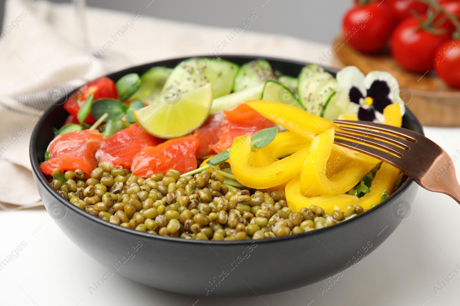 Photo of Bowl of salad with mung beans on white table, closeup