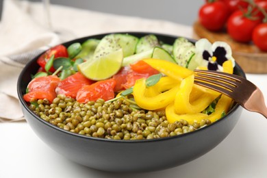 Photo of Bowl of salad with mung beans on white table, closeup