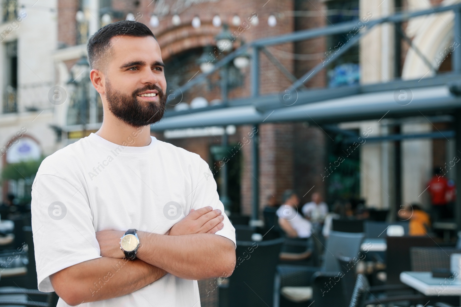 Photo of Portrait of happy handsome man on city street. Space for text