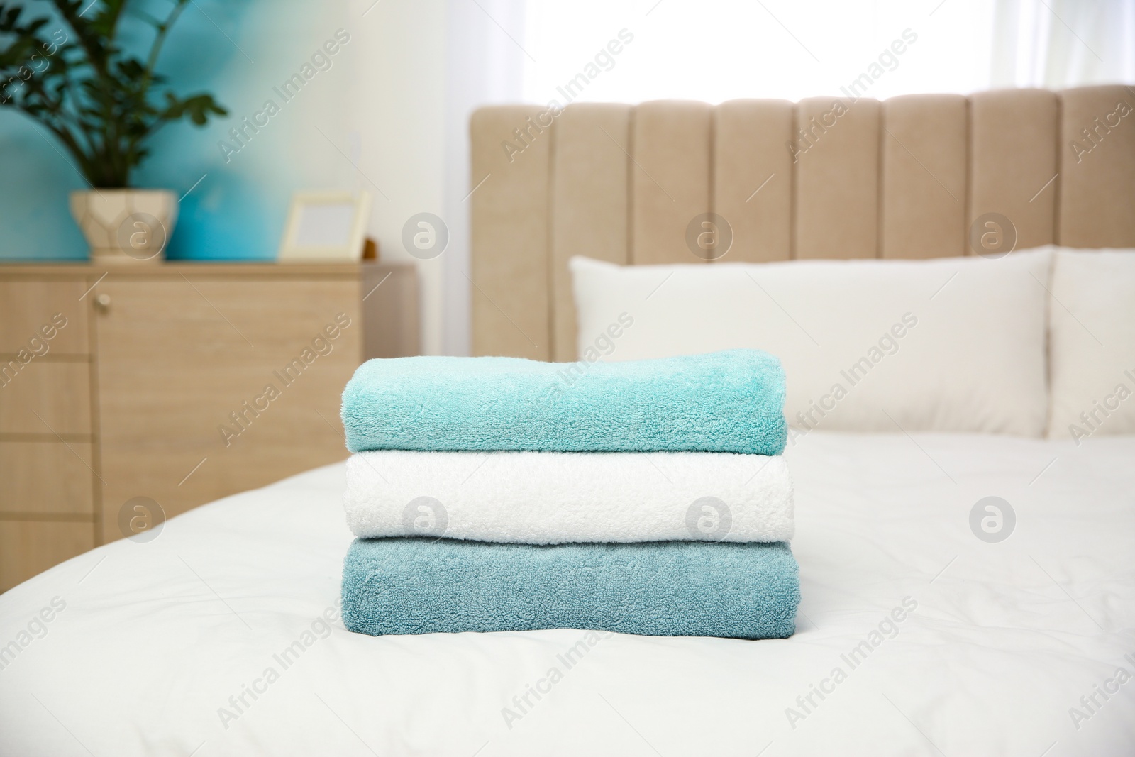 Photo of Soft clean towels on bed at home