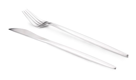 Photo of Shiny silver fork and knife isolated on white. Luxury cutlery