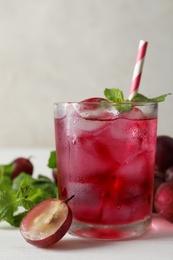 Photo of Delicious grape soda water with mint on white table. Refreshing drink