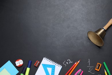 Photo of Flat lay composition with golden bell and school stationery on blackboard, space for text