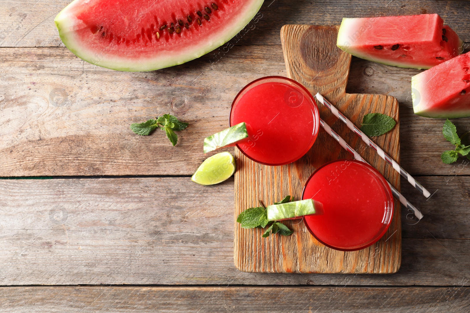 Photo of Summer watermelon drink in glasses, sliced fruits and space for text on table, top view