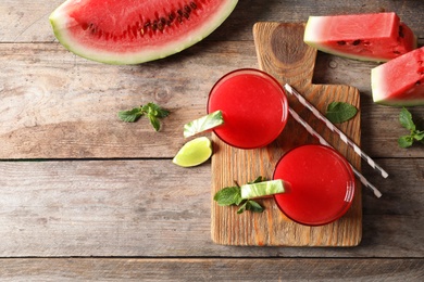 Photo of Summer watermelon drink in glasses, sliced fruits and space for text on table, top view