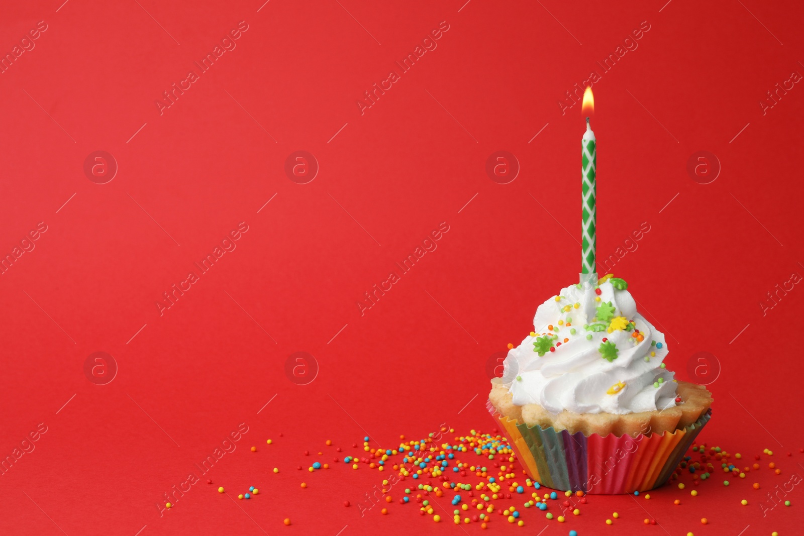 Photo of Birthday cupcake with candle on red background, space for text. Greeting card