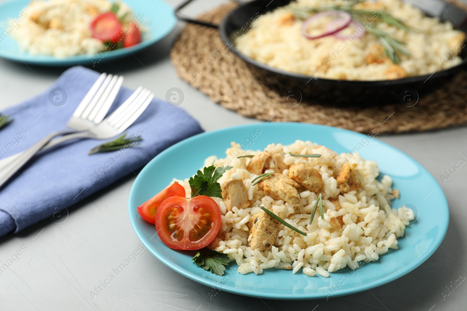 Photo of Delicious chicken risotto served on grey table