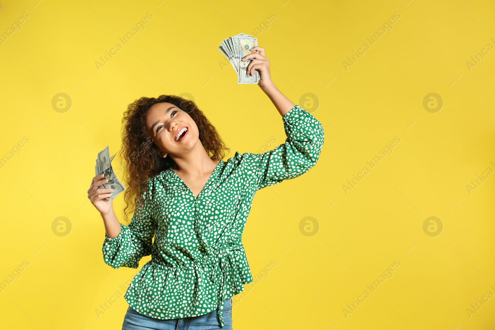 Photo of Young African-American woman with money on color background. Space for text