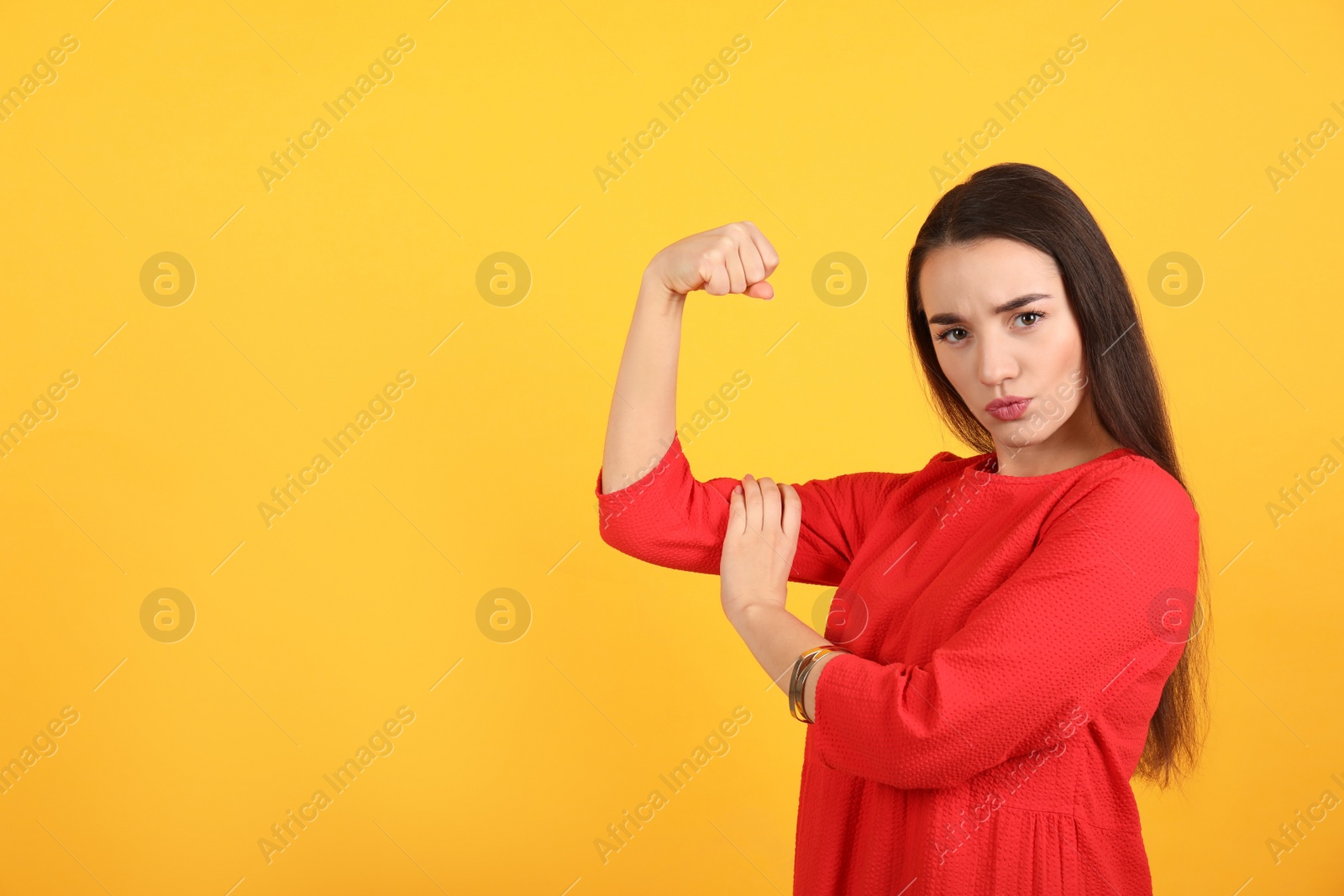 Photo of Strong woman as symbol of girl power on yellow background, space for text. 8 March concept